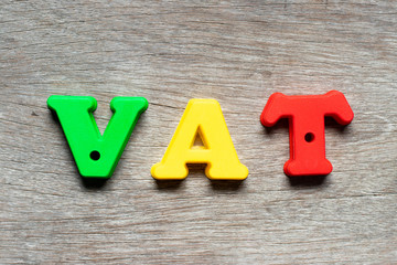 Color alphabet letter in word VAT (Abberviation of Value added tax) on wood background