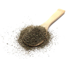 Oregano spice pile in wooden spoon isolated on white background, top view