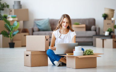 happy   girl with boxes moves to new apartment