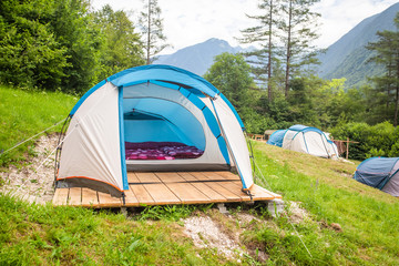 Tent interior with mattresses and purple duvet covers.
