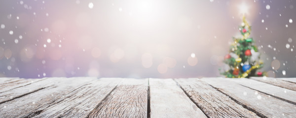 Empty wood table top on blur with bokeh Christmas tree banner background with snowfall - can be...