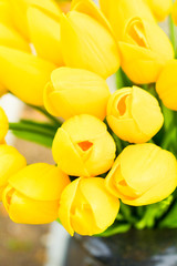 Obraz premium Bouquet of Beautiful Yellow Tulips in Black Stone Vase