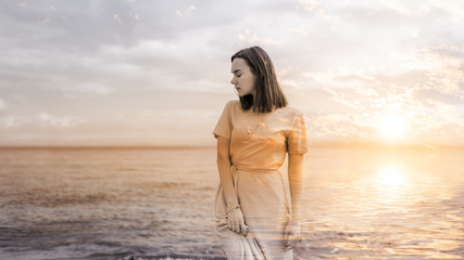 Double exposure of young woman and sunset sky.