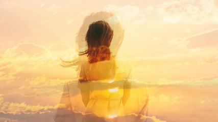 Double exposure of young woman and sunset sky.
