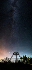 Antenna of the station of exploration of an ionosphere. A silhouette against the background of the night sky with glow and stars.