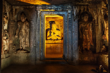 Buddha in beams of artificial lighting.
