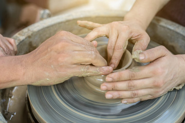Hands working on pottery wheel