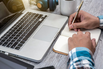 White office desk table with blank notebook, computer keyboard and other office supplies.