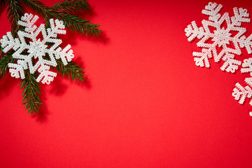 beautiful christmas white stars on a red background with twigs of spruce