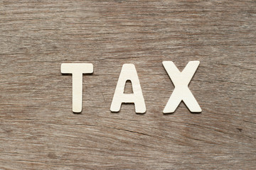 Alphabet letter in word tax on wood background