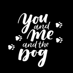 Typographical poster about dog love. Vector motivational lettering You and Me and the Dog. Dog adoption quote with paws. White ink phrase overlay on black background.