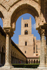 Fototapeta na wymiar Monreale near Palermo, Sicily, cathedral. Tower and cloister, seen through an arch with columns and mosaics in the foreground