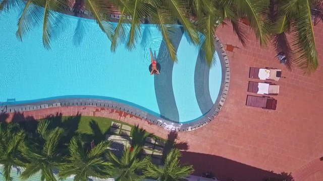 flycam moves to folding chairs and woman in blue pool