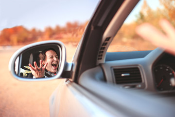 Beautiful angry young woman screaming in her car