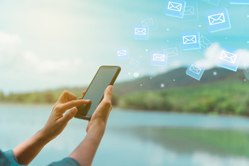 Woman hand using smartphone to send and recieve email.