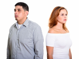 Studio shot of young Hispanic couple with man looking left and woman look