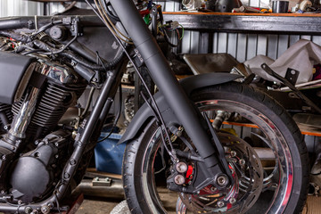 Cropped close up shot of beautiful and custom made motorcycle in the workshop