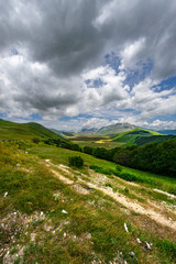 Fototapeta na wymiar Sentieri di montagna con veduta sulla vallata di Castelluccio di Norcia