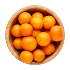 Fresh whole kumquats in wooden bowl isolated on white background. Top view.