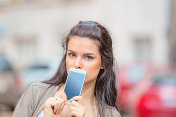 Cute young woman using cellphone in urban surroundings.