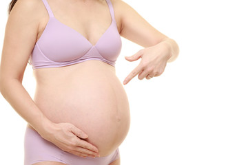 妊娠していることをアピールする薄紫色の下着を着た臨月の妊婦