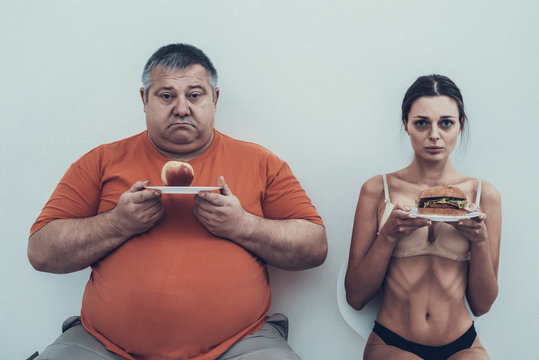 Fat Man and Anorexic Girl with Plates with Food.