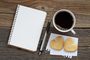 Notebook, pen and coffee with cookies