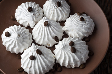 Sweet dessert - vanilla marshmallow (zephyr) on a wooden table with coffee beans, selective focus.