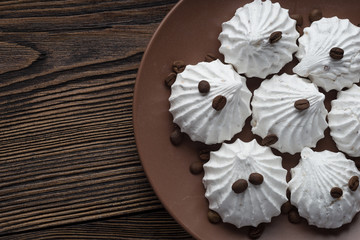 Sweet dessert - vanilla marshmallow (zephyr) on a wooden table with coffee beans, selective focus.