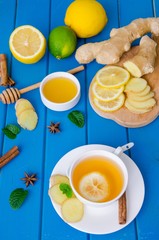 Ginger tea with lemon and honey on blue wooden background