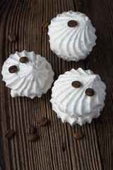 Sweet dessert - vanilla marshmallow (zephyr) on a wooden table with coffee beans, selective focus.