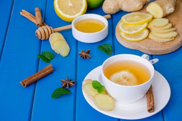 Ginger tea with lemon and honey on blue wooden background