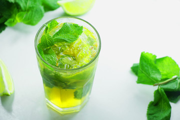 Mojito cocktail with lime and mint in glass on a white backgroun