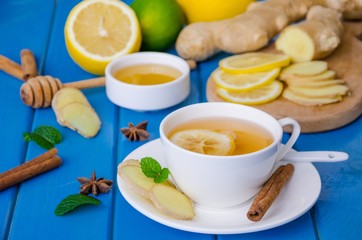 Ginger tea with lemon and honey on blue wooden background
