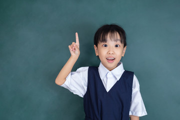 Asian chinese little girl in uniform pointing finger up