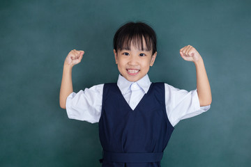 Asian Chinese little girl in uniform standing with arms up