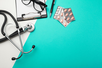 Stethoscope, clipboard and pills, closeup. Medical equipment