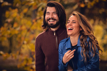 Couple in autumn season colored park enjoying outdoors.