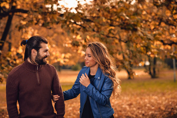 Couple in autumn season colored park enjoying outdoors.