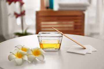 Glass bowl with sugaring paste, strips and flowers on white table