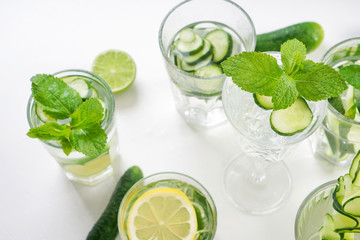Glasses of fresh cucumber water on white table