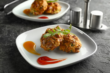 Plate with tasty sausage balls on table