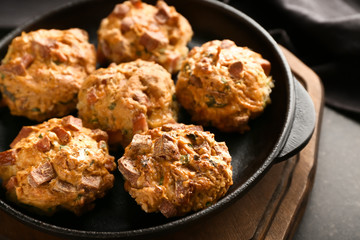 Frying pan with tasty sausage balls on wooden board, closeup