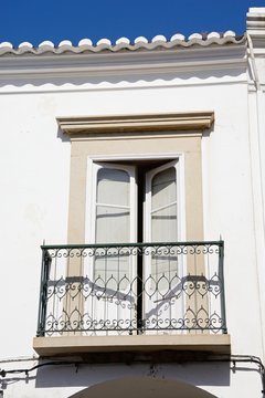 Traditional Portuguese building with a small balcony in the old town, Tavira, Algarve, Portugal.