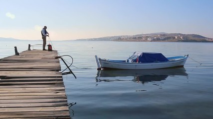 Ships boy knotting rope on a boat.
