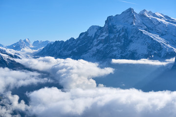 First snow and winter mountain landscape in mid october with clouds in the valley. Jungfrau region in Switzerland.