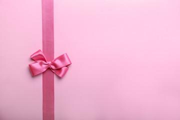 Pink ribbon with bow on color table
