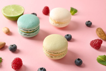 Composition with tasty macaroons, blueberry, raspberry and nuts on color background