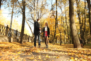 Fototapeta premium couple people young man and women walking autumn park fanny sunny day