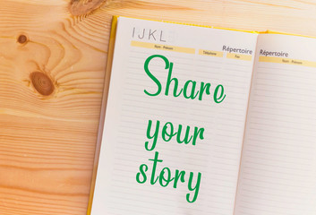 share Your Story word on notebook on wooden table 